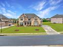 Beautiful two-story home with brick and stone, an expansive yard, and a long driveway at 4720 Gablestone Xing, Hoschton, GA 30548
