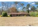Spacious single-story home with a large front yard and mature trees, offering curb appeal and outdoor space at 4892 Duncan Dr, Powder Springs, GA 30127