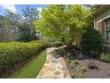 Charming stone path leads to the front entrance, framed by lush greenery and mature trees at 9860 Coleman Rd, Roswell, GA 30075