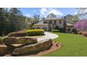 Beautifully landscaped front yard with mature trees and a long circular driveway leading to the home at 9860 Coleman Rd, Roswell, GA 30075