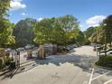 Bentley Place entrance with gated entry and mature trees on sunny day at 112 Bentley Pl, Tucker, GA 30084