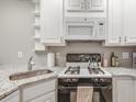 Well-equipped kitchen with white cabinetry, modern appliances, and granite countertops at 215 Piedmont Ne Ave # 904, Atlanta, GA 30308