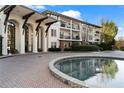 Condominium entrance with covered portico, brick driveway, and water feature at 3101 Howell Mill Nw Rd # 201, Atlanta, GA 30327