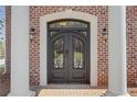 Elegant brick home featuring a stately front entry with a decorative iron door and sconces at 3485 Walnut Rdg, Atlanta, GA 30349