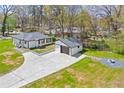 Renovated home featuring a detached garage, new driveway, and a landscaped yard with a cozy fire pit at 936 South Ave, Forest Park, GA 30297