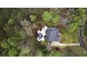 An aerial view of a private backyard oasis featuring a dark pool, lush landscaping, and nestled among mature trees at 12680 Old Surrey Pl, Roswell, GA 30075