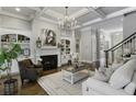 Elegant living room with a cozy fireplace, custom built-ins, hardwood floors, and plenty of natural light at 12680 Old Surrey Pl, Roswell, GA 30075