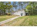 Split-level home with a white exterior, and a staircase leading to a backyard deck at 3656 Tulip Dr, Decatur, GA 30032