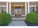 Elegant front door entrance featuring white pillars, sidelights, and manicured landscaping at 3740 Williams Point Dr, Cumming, GA 30028