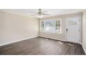 Bright living room with hardwood floors, a ceiling fan, and a large window for natural light at 10164 Sunny Sw Dr, Covington, GA 30014
