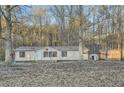 Single-story home with a storage shed in a spacious yard with mature trees surrounding the property at 355 Double D Rd, Temple, GA 30179