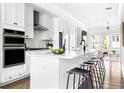 Modern white kitchen featuring stainless steel appliances and a breakfast bar at 6701 Prelude Dr, Atlanta, GA 30328