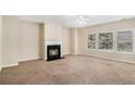 Cozy living room with a fireplace, plush carpeting, and large windows offering natural light at 2134 Shropshire Se Ln, Atlanta, GA 30316