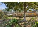 Spacious front yard with mature trees, a bench and brick home in the background at 2373 Woodcreek Ct, Tucker, GA 30084
