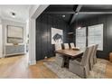 Modern dining room with a dark accent wall, a wooden table with seating for six, and striking light fixture at 2595 Apple Valley Rd, Brookhaven, GA 30319