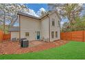 Back exterior view with fenced yard, small patio area, and neutral-colored siding at 3637 Elm St, Atlanta, GA 30354