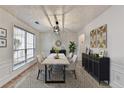 Elegant dining room with modern light fixture, wainscoting, and large windows for natural light at 3550 Lakeheath Dr, Cumming, GA 30041