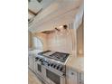 Gourmet kitchen features a professional-grade Wolf range and custom stone vent hood at 2440 Peachtree Nw Rd # 22, Atlanta, GA 30305