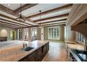 Expansive living room boasts exposed beams, travertine floors, and access to a balcony at 2440 Peachtree Nw Rd # 22, Atlanta, GA 30305