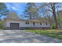 A single-story home features a driveway leading to an integrated garage at 3016 Deshong Dr, Stone Mountain, GA 30087