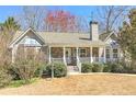 Charming single-story home with a stone and siding exterior, white porch, and manicured landscaping at 189 Meadow Spring Dr, Temple, GA 30179