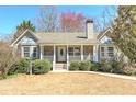 Charming single-story home with a stone and siding exterior, white porch, and manicured landscaping at 189 Meadow Spring Dr, Temple, GA 30179