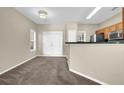 Neutral living room with double doors leading outside and kitchen bar in the background at 2138 Mill Garden Run, Buford, GA 30519