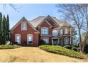 Charming two-story brick home with a well-manicured front lawn and inviting curb appeal at 1037 Windermere Xing, Cumming, GA 30041