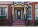 Close-up of the elegant front door with decorative sidelights and brick steps leading to the entrance at 1037 Windermere Xing, Cumming, GA 30041