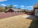 A spacious backyard featuring a brown wooden fence and a small concrete patio at 1705 Rolling View Dr, Cumming, GA 30040