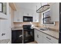Well-lit kitchen featuring granite counters, white cabinets, and modern black appliances at 1687 Briarcliff Ne Rd # 8, Atlanta, GA 30306