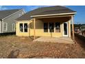 A new home with a covered patio and large windows overlooking a partially landscaped backyard at 1243 Lakeside Overlook, Canton, GA 30114