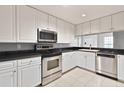 Modern kitchen with white cabinetry, stainless steel appliances, and black countertops at 195 14Th Ne St # 2402, Atlanta, GA 30309