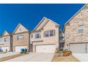 Attractive townhome displays a two-car garage and brick facade under a clear blue sky at 2463 Quay Rdg, Lawrenceville, GA 30044