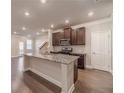 Modern kitchen features granite countertops, dark wood cabinets, and stainless steel appliances at 2463 Quay Rdg, Lawrenceville, GA 30044