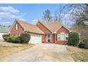 Beautiful brick home features a well-manicured front lawn, a long driveway, and a two-car garage at 625 Sycamore Glen Nw Ct, Lawrenceville, GA 30044