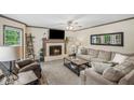 Cozy living room featuring a brick fireplace, neutral furniture, and a large window overlooking a greenery view at 1945 Wenlok Ne Trl, Marietta, GA 30066