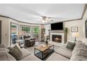Inviting living room with fireplace, ceiling fan, neutral furniture, and natural light from adjacent windows at 1945 Wenlok Ne Trl, Marietta, GA 30066