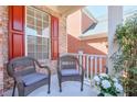 Charming front porch with wicker chairs, offering a cozy outdoor seating area with potted plants at 3878 Kingsley Park Ln, Peachtree Corners, GA 30096