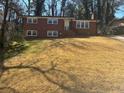 Beautiful two-story brick home with a spacious front yard and mature trees at 2703 Rainbow Forest Dr, Decatur, GA 30034