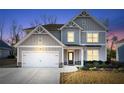 Inviting two-story home with an attached two-car garage and well-maintained front yard at twilight at 7545 Rambling Vale, Cumming, GA 30028