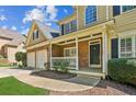 Inviting front porch with stone accents, a white railing, a black front door, and well-maintained landscaping at 5815 P.W.A. Dr, Cumming, GA 30041