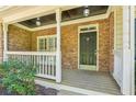 Close-up view of a cozy front porch with stone detailing, a classic black door, and a neat white railing at 5815 P.W.A. Dr, Cumming, GA 30041