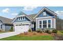 Charming home featuring light blue and gray siding, a two-car garage, and nicely landscaped front yard at 67 Narrowleaf Ln, Dallas, GA 30157