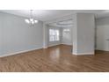 Spacious living room featuring hardwood floors and elegant chandeliers that amplify the bright, open space at 3455 Flycatcher Way, Duluth, GA 30097