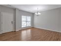 Bright living room with hardwood floors, a large window, and a stylish chandelier that enhances the space at 3455 Flycatcher Way, Duluth, GA 30097