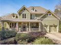 Inviting two-story home featuring a charming front porch and a two-car garage at 3828 Morning Meadow Ln, Buford, GA 30519