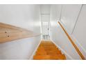 Bright staircase showcasing hardwood steps and white walls leading to a white door at 1433 Carroll Drive Nw, Unit #3, Atlanta, GA 30318