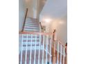 Elegant staircase with white risers and wooden handrail, enhancing the home's interior appeal at 523 Lantern Wood Dr, Scottdale, GA 30079