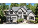 Attractive two-story traditional home with brick exterior, attached two-car garage, and mature trees at 320 N Drew Ct, Duluth, GA 30097